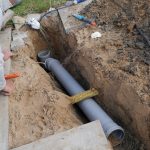 Plumbing professional working on sewer pipe